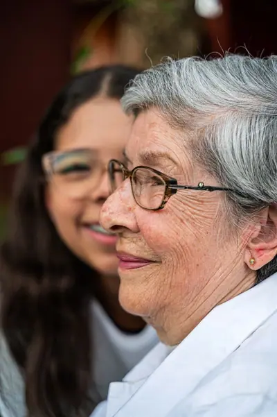 Avó e neta sorriem lado a lado, bem próximas